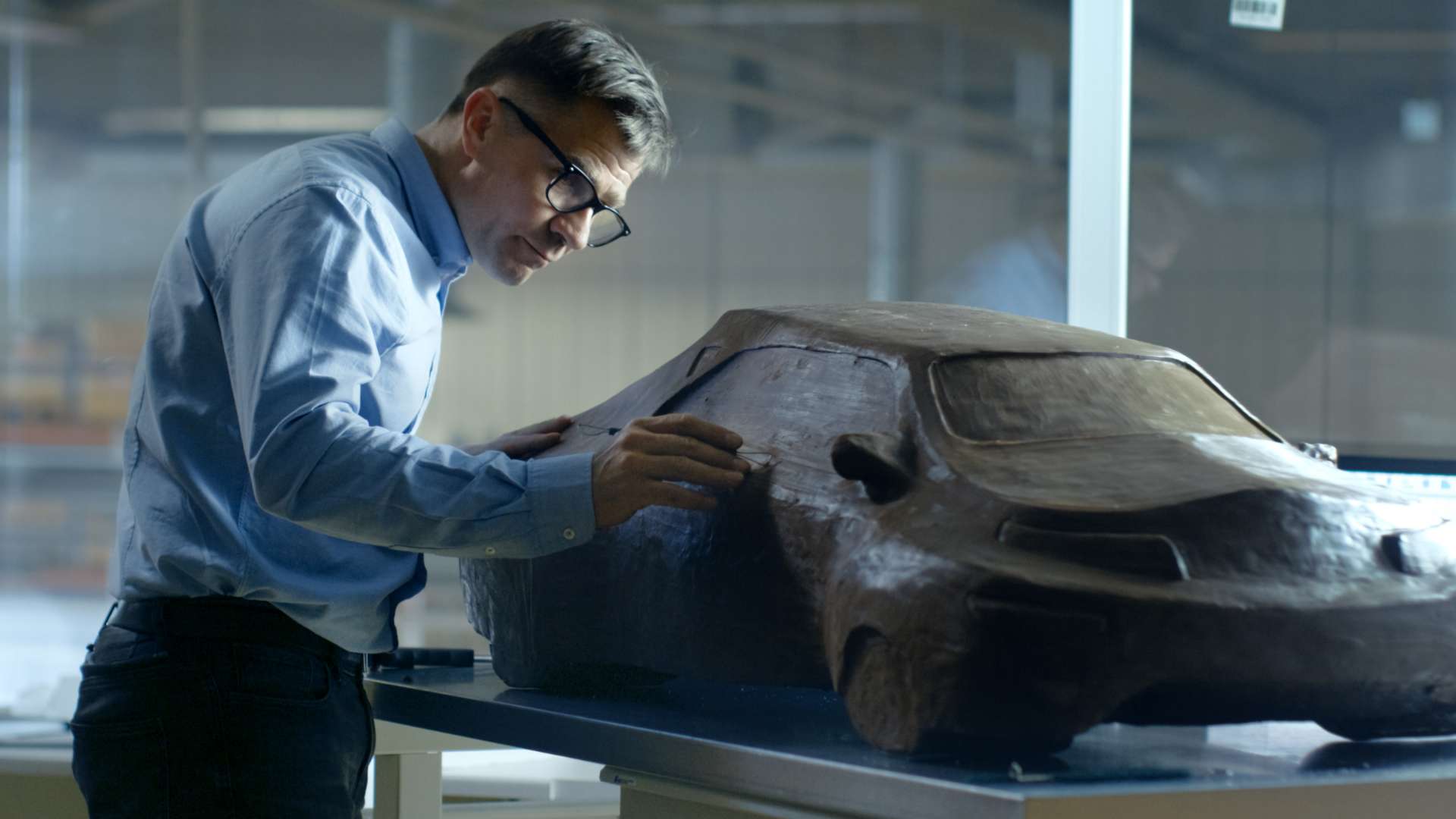 Man in a suit working on clay car